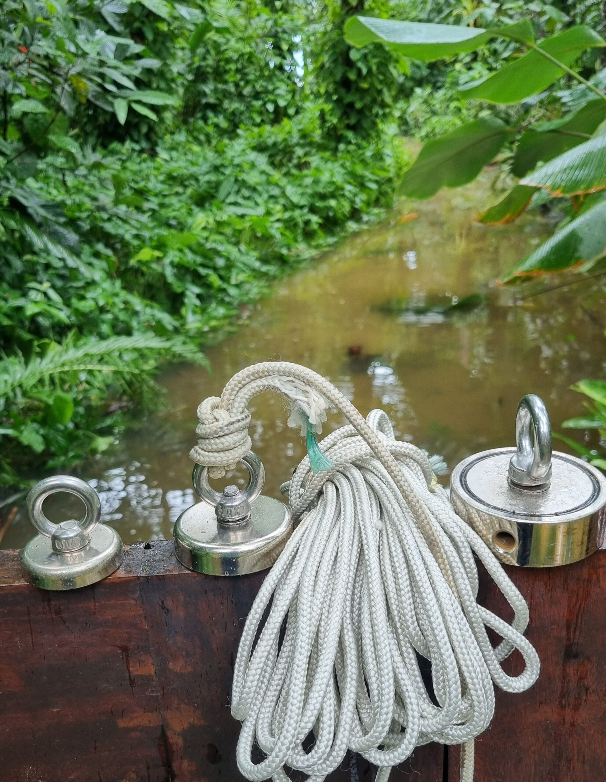 Praticante realizando pesca magnética ao ar livre com corda e ímã